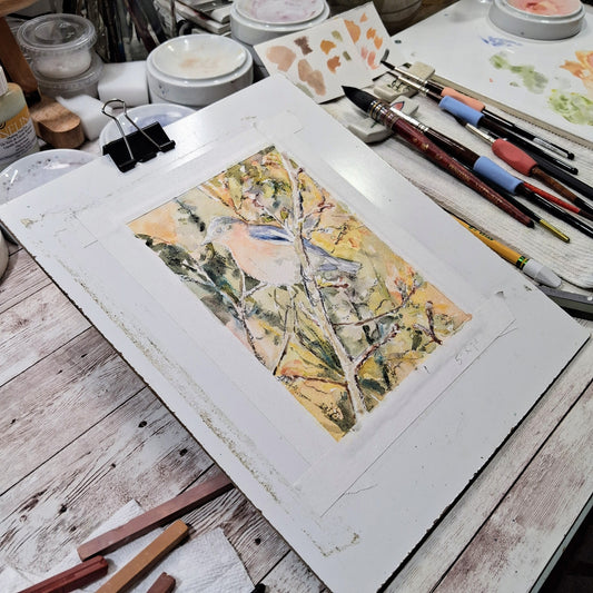 A 5: x 7" watercolor painting of a bluebird on a branch in progress.