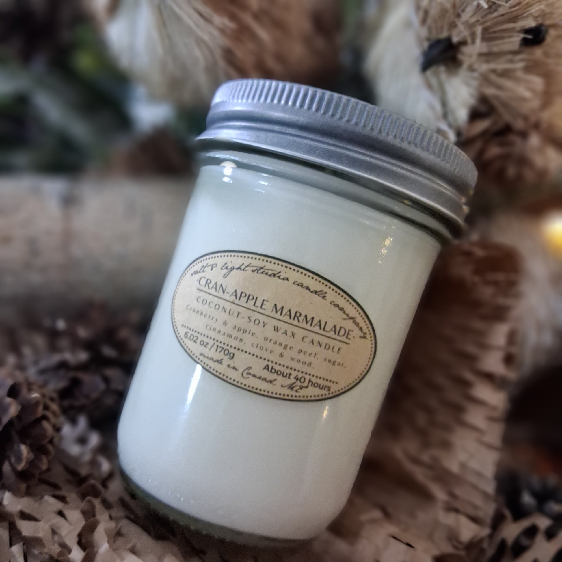 Cranberry Apple Marmalade coconut soy candle in glass jar with metal lid on a rustic natural background