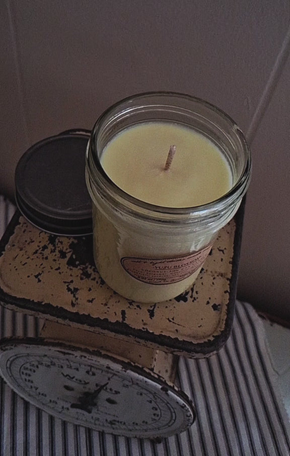 lighting a coconut soy wax candle with a match, hand poured in small batches, golden glow of candle flame